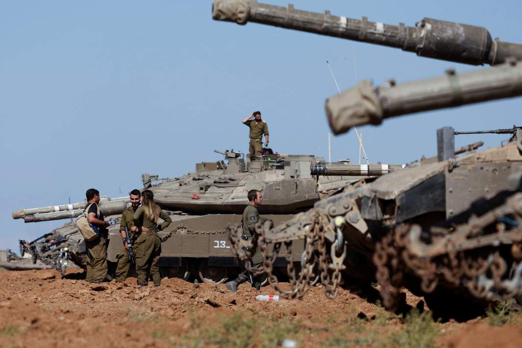 Израильские солдаты стоят рядом с военными транспортными средствами на фоне продолжающегося конфликта между Израилем и палестинской исламистской группировкой ХАМАС