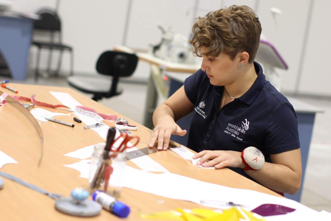 парень отмеряет заготовки для резки ткани