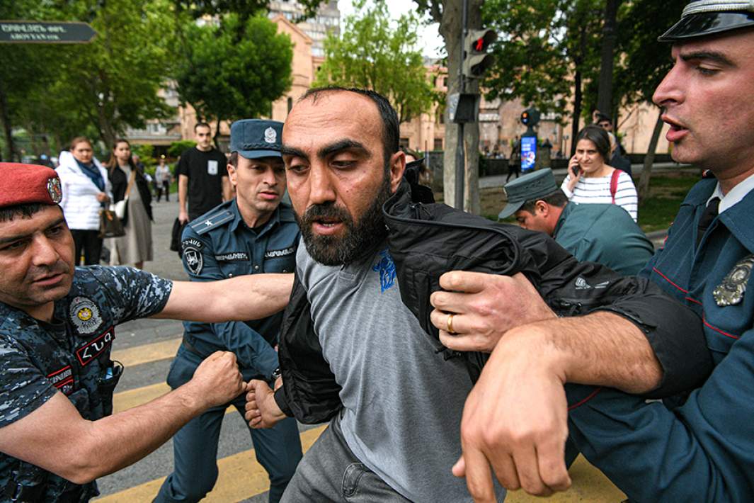Сотрудники полиции и участник протестной акции в Ереване