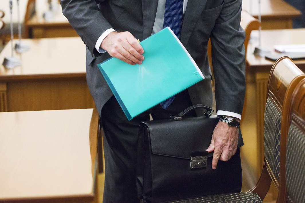 мужчина в офисе убирает свои бумаги в сумку