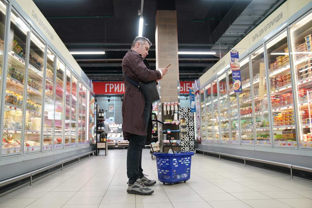 мужчина стоит в магазине продуктов