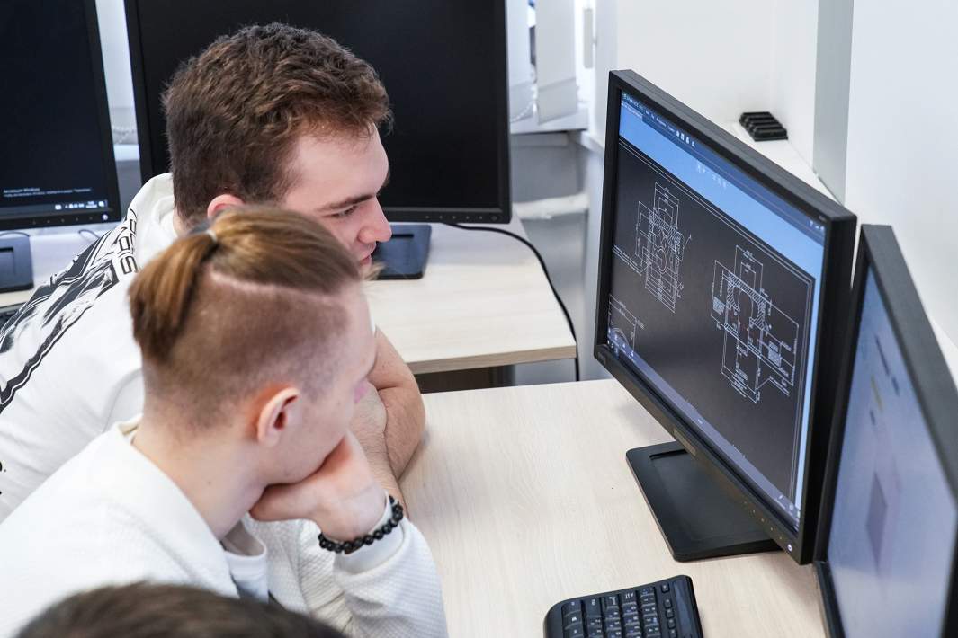 два человека смотрят в компьютер работают в айти