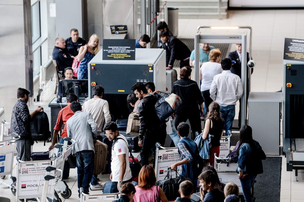 аэропорт пассажиры проходят проверку в раме металлоискателя