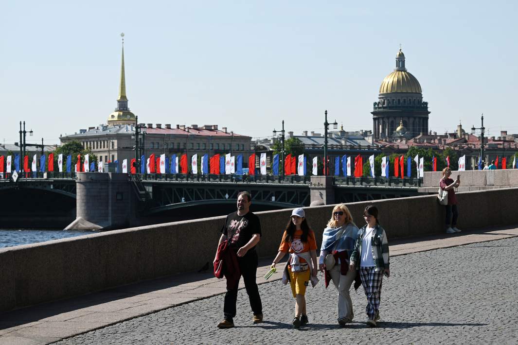 Люди гуляют по набережной в Санкт-Петербурге