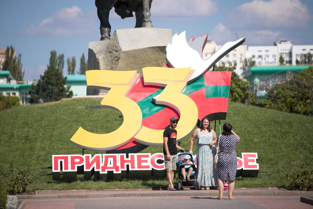 Люди фотографируются на площади Суворова в Тирасполе на День республики на фоне инсталляции к 33-летию Приднестровской Молдавской Республики
