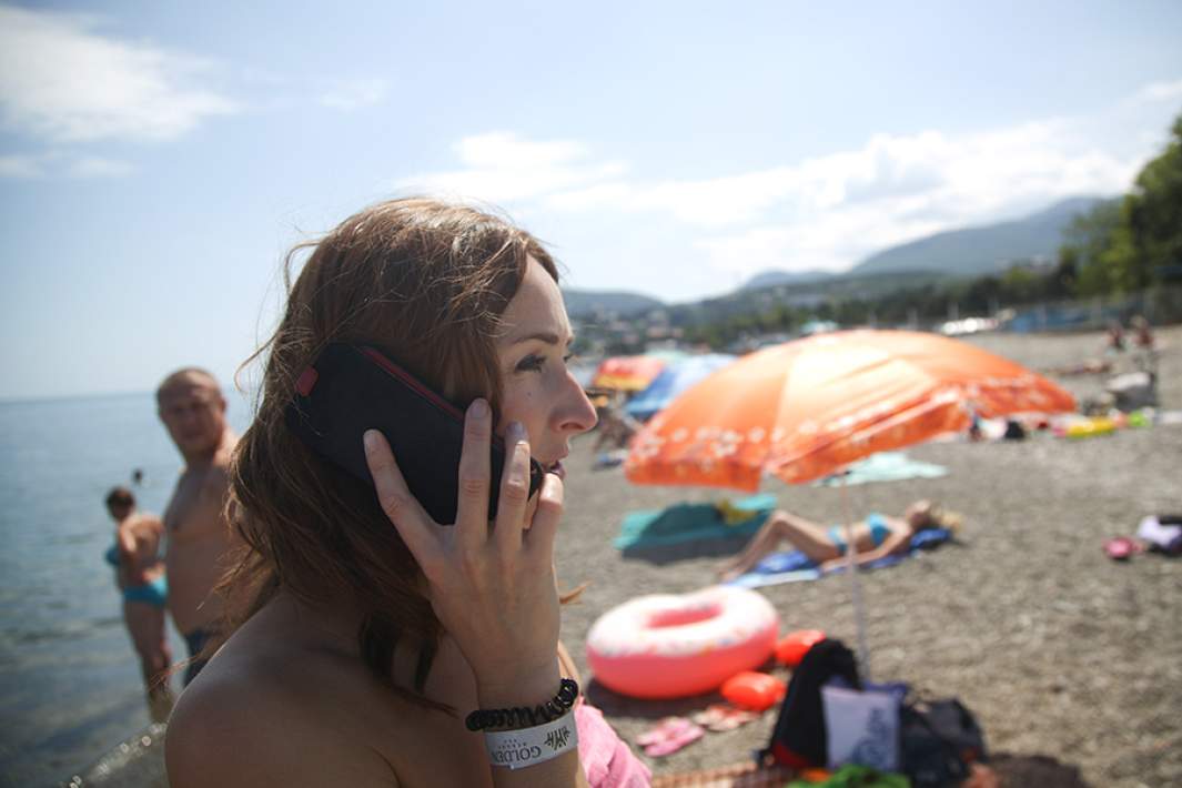 Девушка разговаривает по телефону на пляже