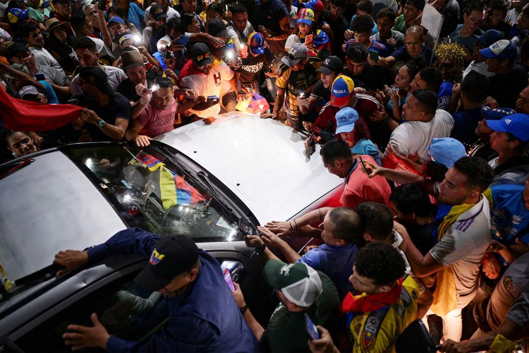 Сторонники лидера венесуэльской оппозиции Марии Корины Мачадо окружают автомобиль Мачадо во время предвыборного митинга по президентским выборам 
