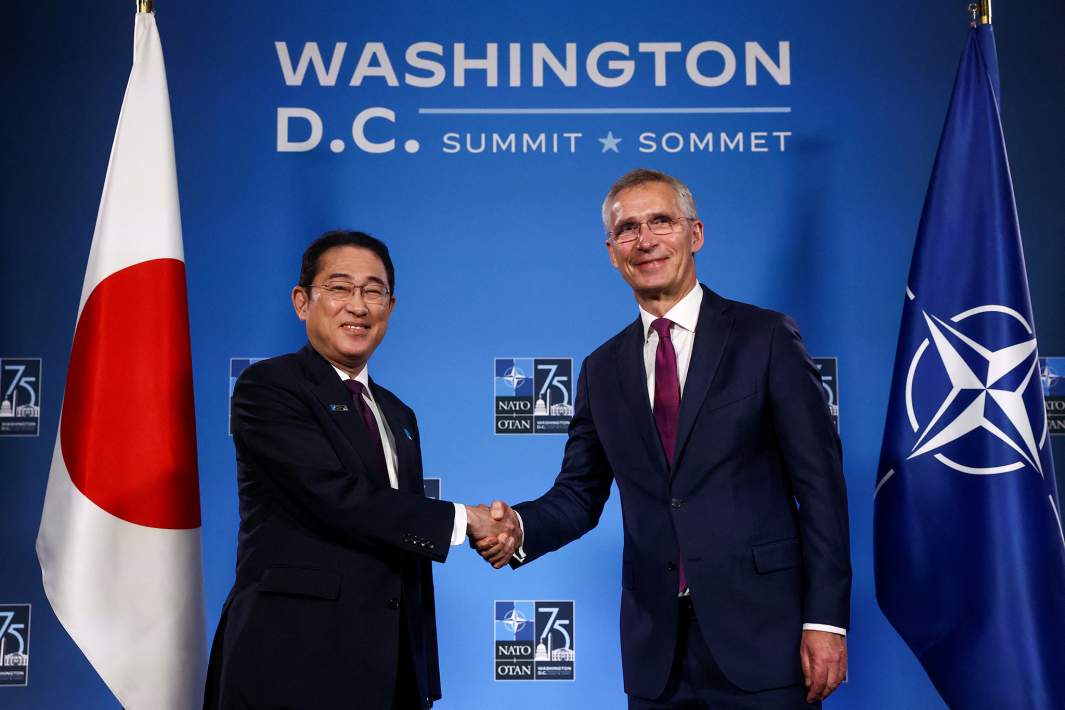 Слева направо: премьер-министр Японии Фумио Кисида и генеральный секретарь НАТО Йенс Столтенберг пожимают друг другу руки