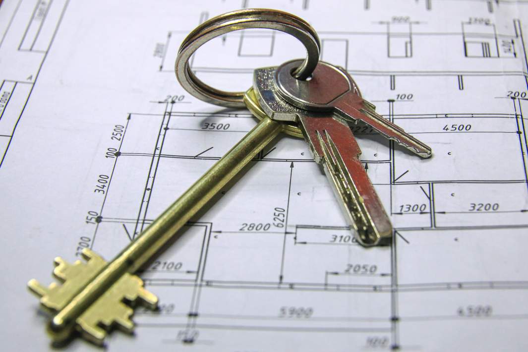 Ключи от квартиры на фоне плана строительства