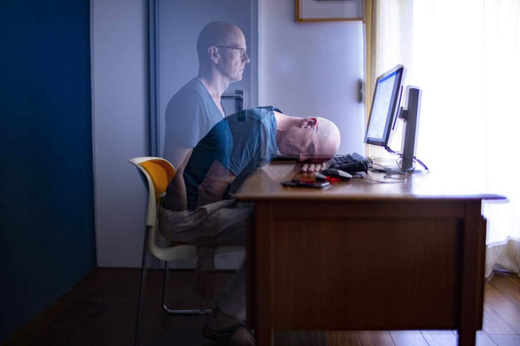 Сонный человек за компьютером