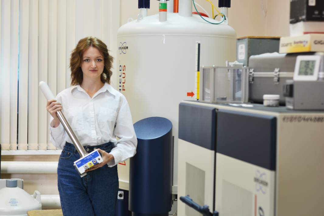 Первый автор работы, инженер-исследователь Валентина Соборнова держит датчик ЯМР спектрометра, в который помещают исследуемый образец вещества
