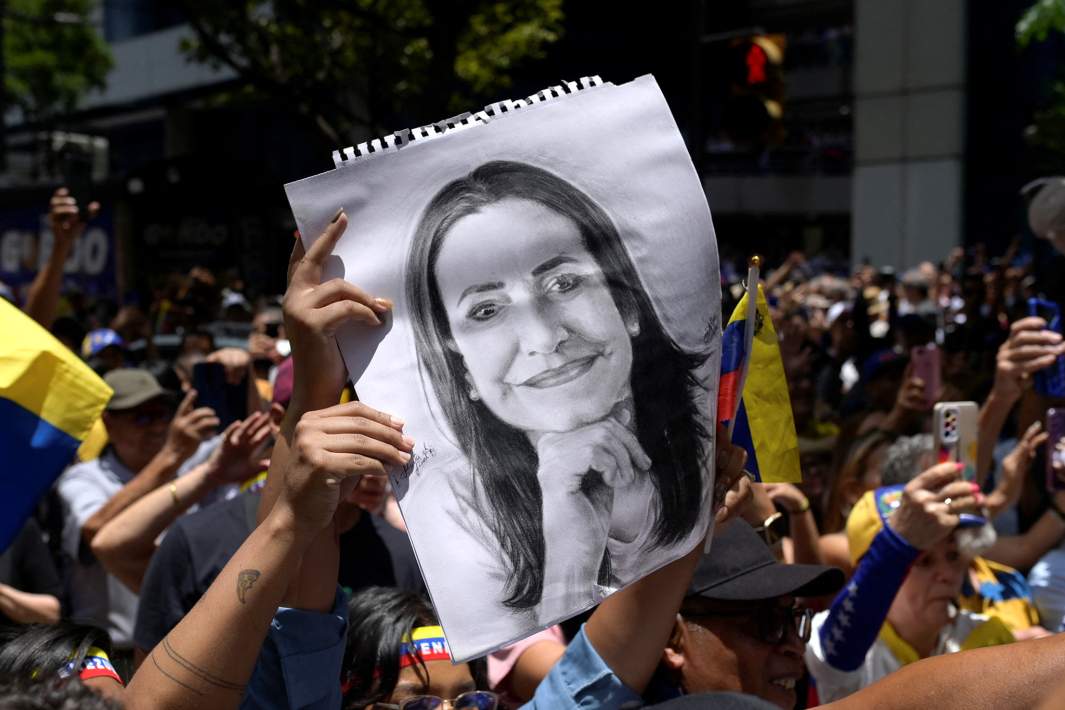 Портрет лидера оппозиции Марии Корины Мачадо в руках сторонников оппозиции на улицах Каракаса