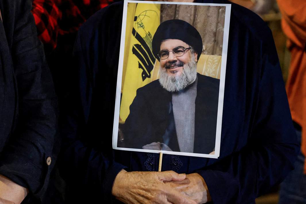 Мужчина держит фотографию лидера ливанской «Хезболлы» Хасана Насраллы