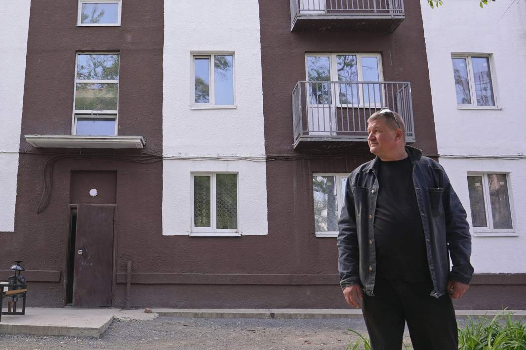 Местный активист Павел на фоне восстановленного дома