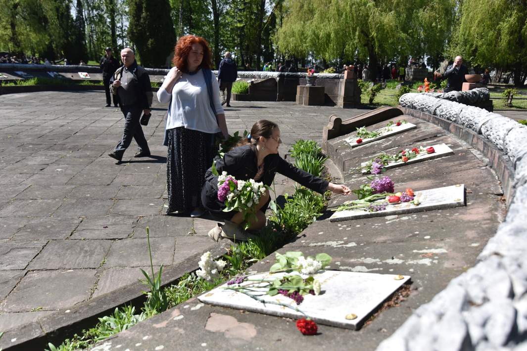 Жители Львова возлагают цветы к мемориальным плитам на Холме Славы в День Победы