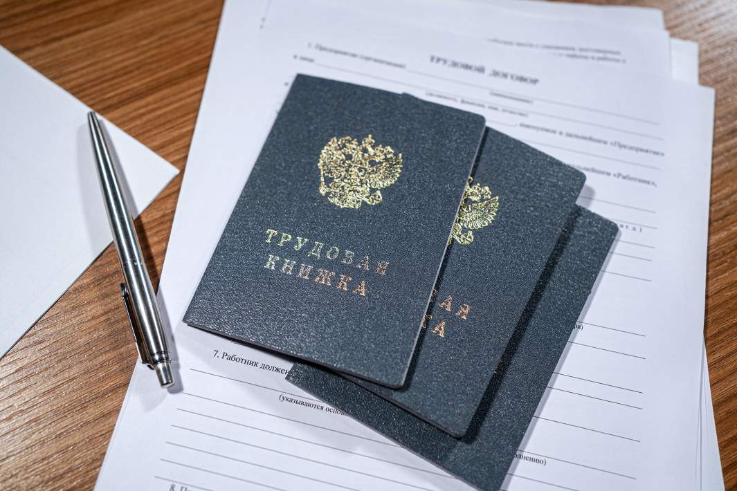 Трудовая книжка и трудовой договор на столе