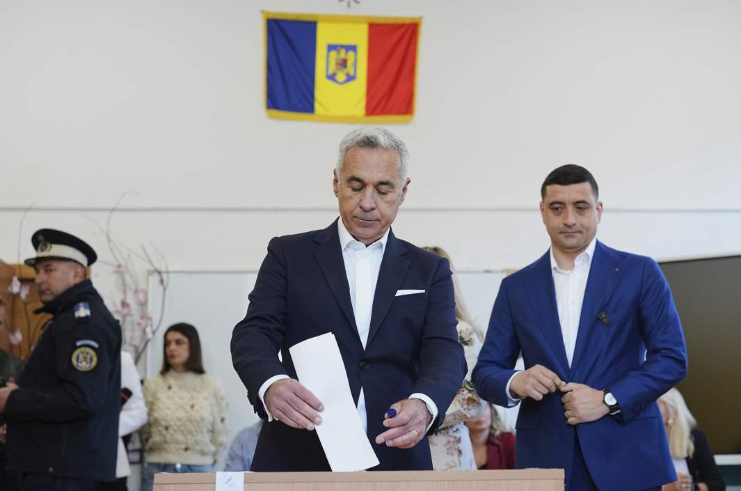 Кэлин Джеорджеску, победитель первого тура аннулированных выборов прошлого года (в центре), голосует рядом с кандидатом в президенты Джорджем Симионом во втором туре повторных президентских выборов в Могошоае, Румыния,18 мая 2025 года