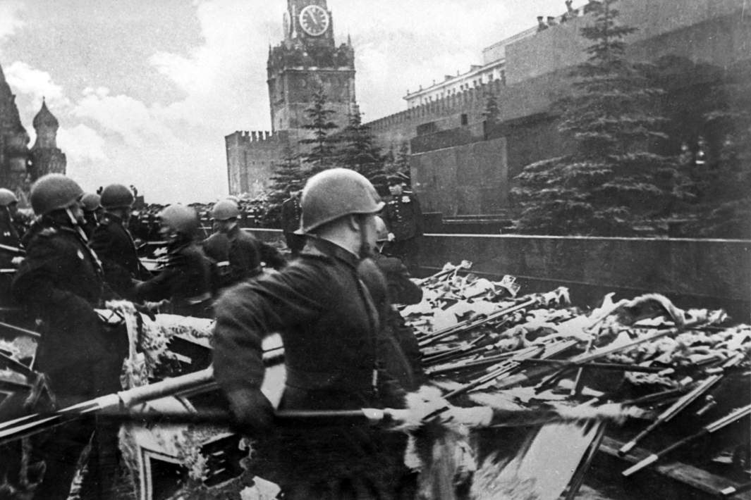 Участники парада бросают к подножию Мавзолея В. И. Ленина немецкие знамена