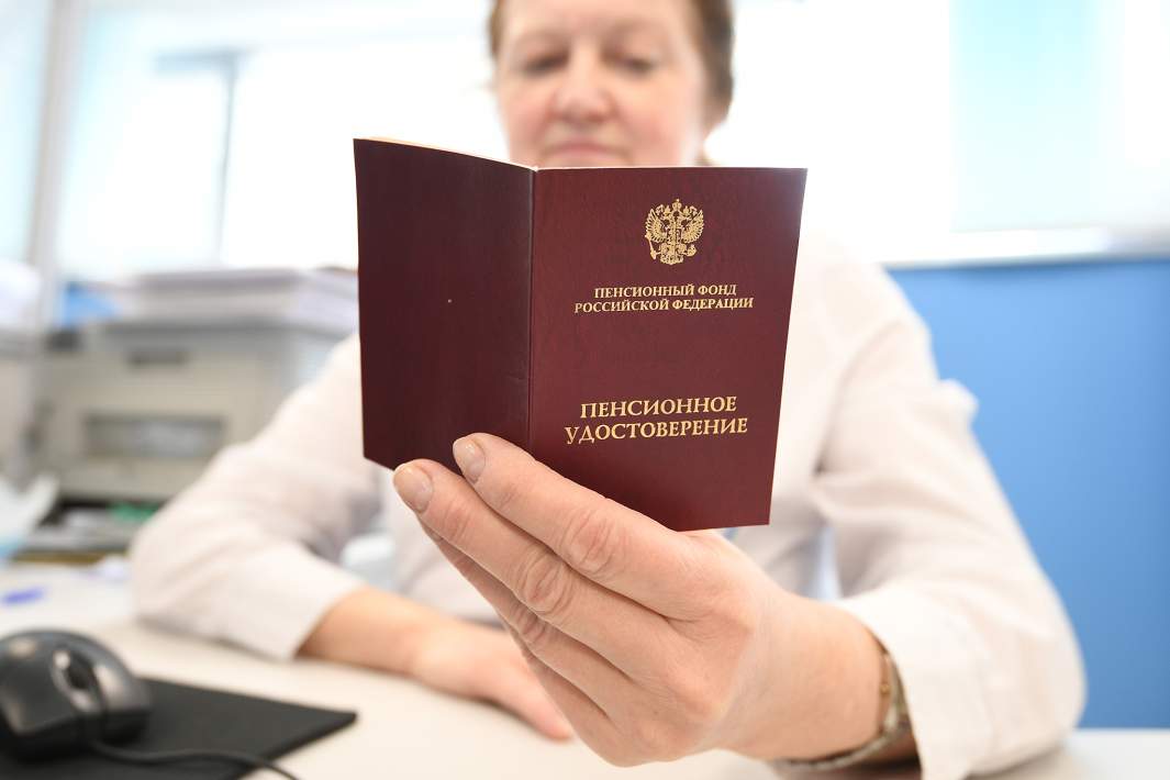 Сотрудник ПФР держит в руках пенсионное удостоверение