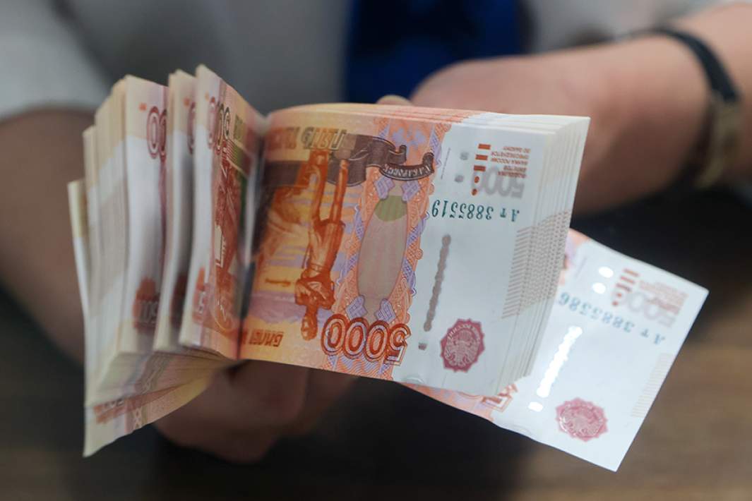 Банкноты номиналом 5000 российских рублей в руках кассира 