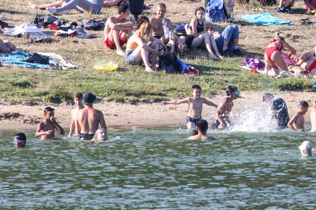 Люди купаются в пруду 