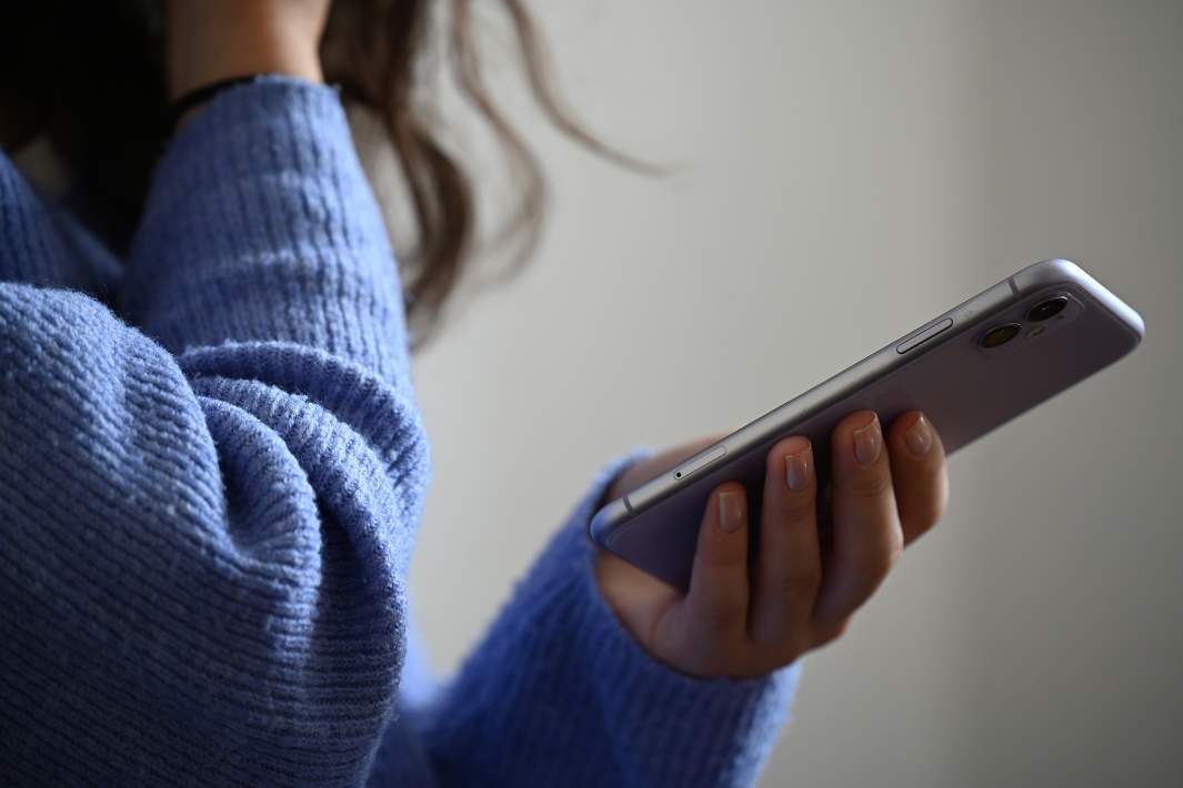 Девушка держит в руке телефон 