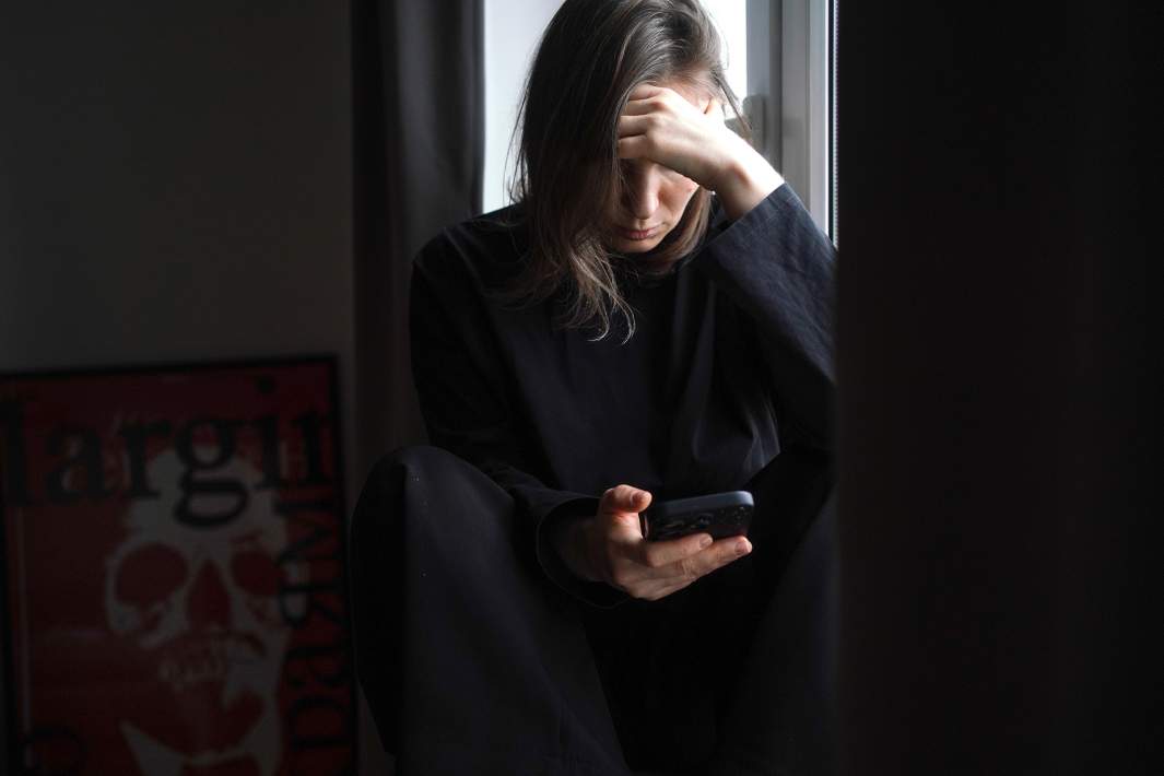 Женщина у окна в своей квартире