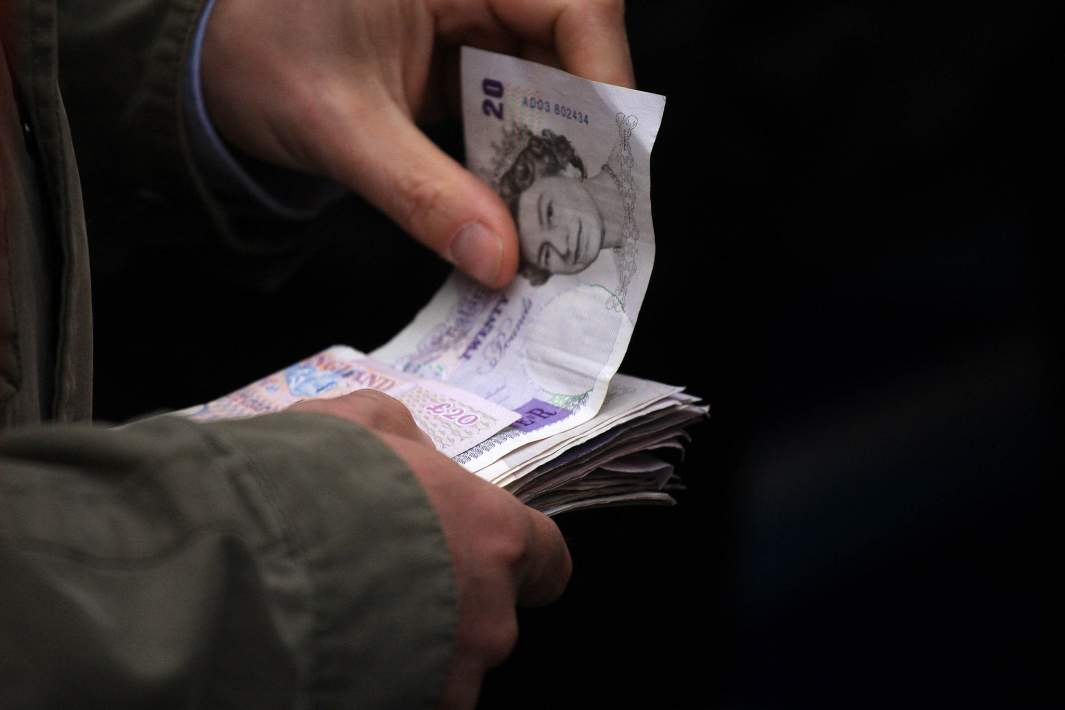 Фунты стерлингов в руках мужчины
