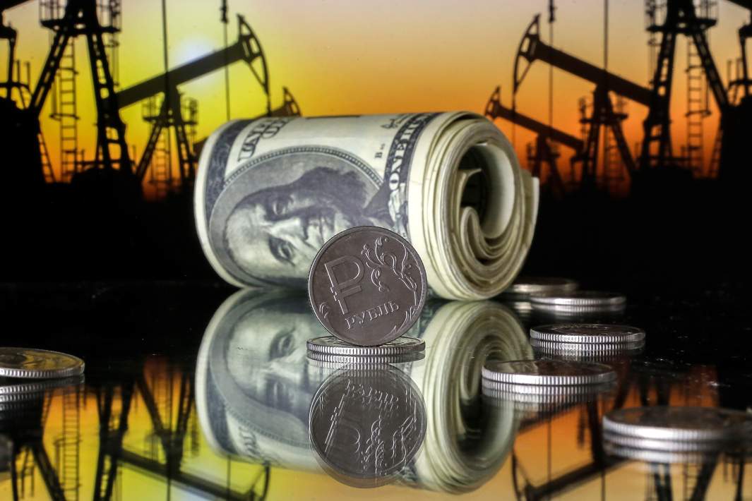 Купюры доллара и монета рубль