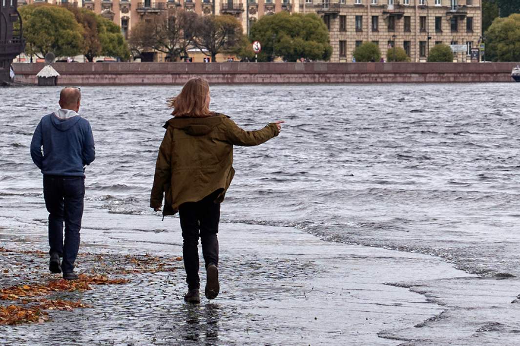 Люди идут по набережной реки Невы в Санкт-Петербурге