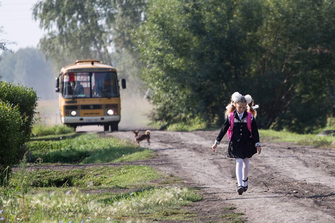 Девочка бежит на остановку школьного автобуса