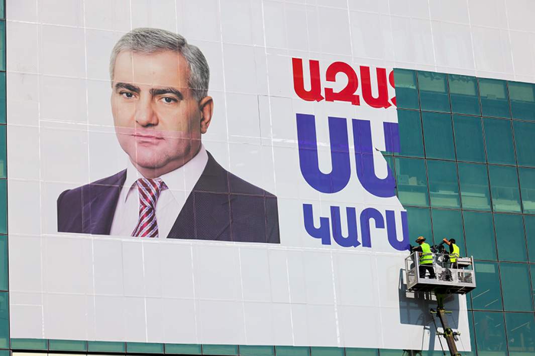 Рабочие на подъемнике демонтируют баннер с надписью «Свободу Самвелу Карапетяну» с принадлежащего ему торгового центра «Ташир»