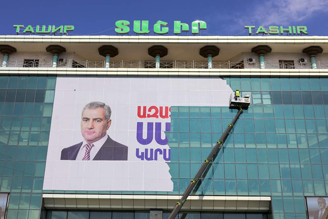 Рабочие на подъемнике демонтируют баннер с надписью «Свободу Самвелу Карапетяну» с принадлежащего ему торгового центра «Ташир» в Ереване