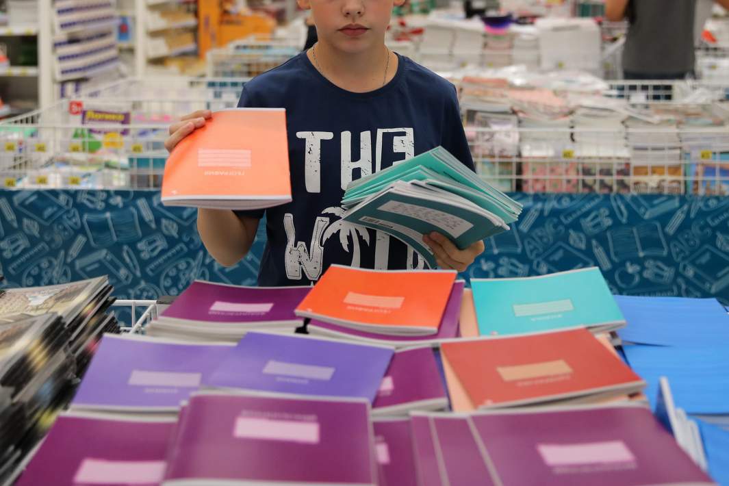 Школьник держит в руках тетрадки 