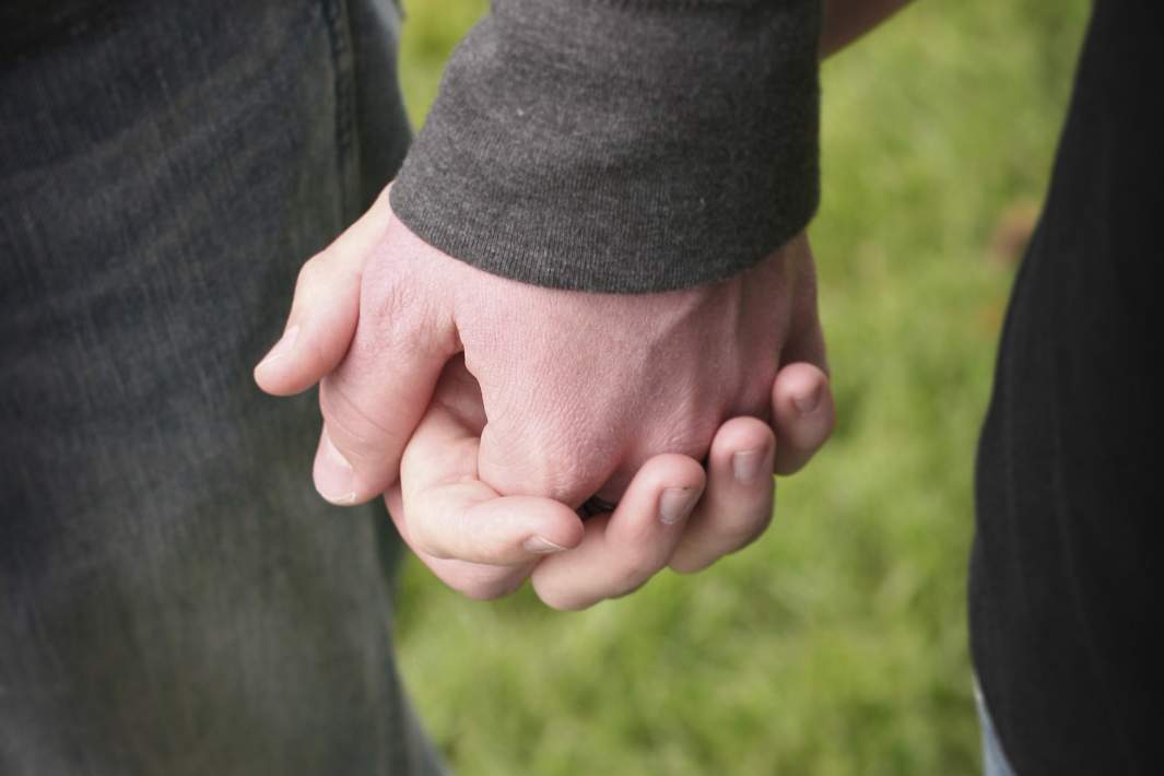 Мужчина и женщина держаться за руки 