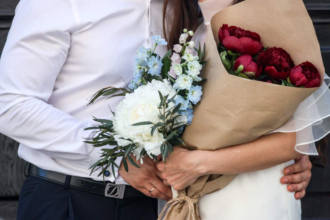 Жених и невеста держат цветы 