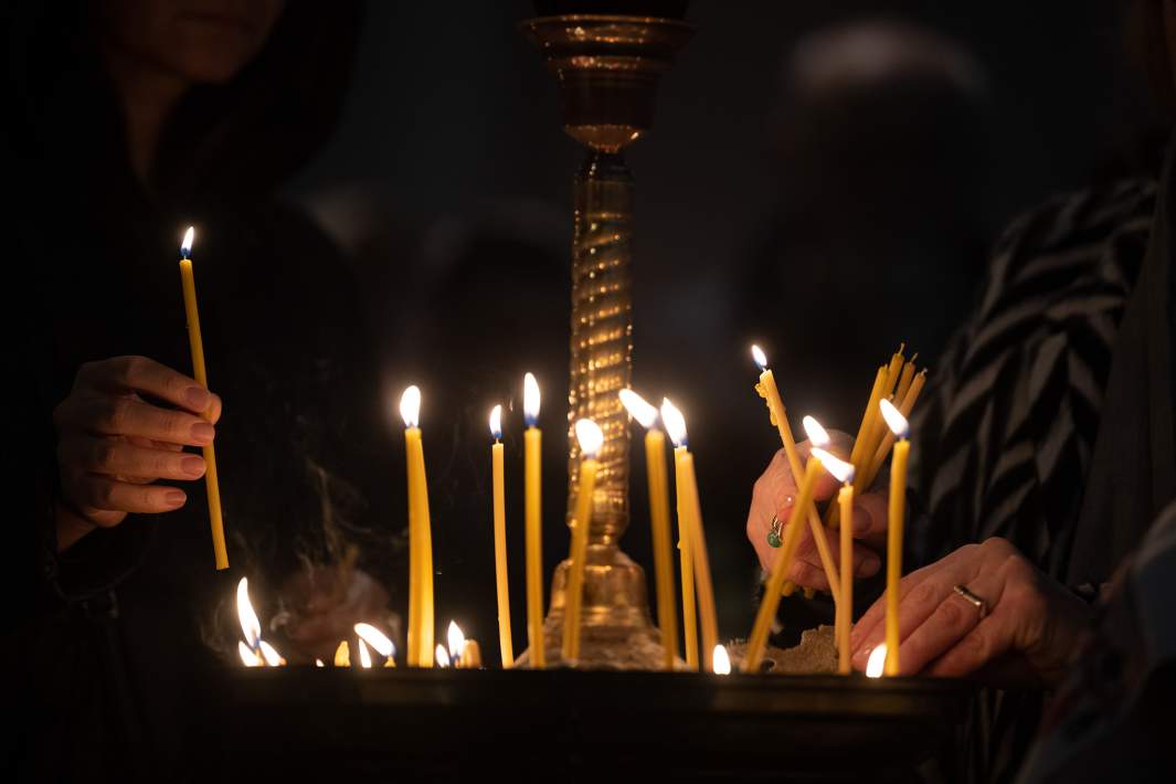 Верующие ставят свечи 