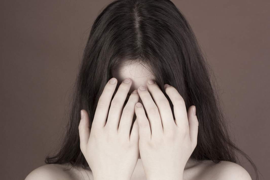 Женщина прячет лицо 