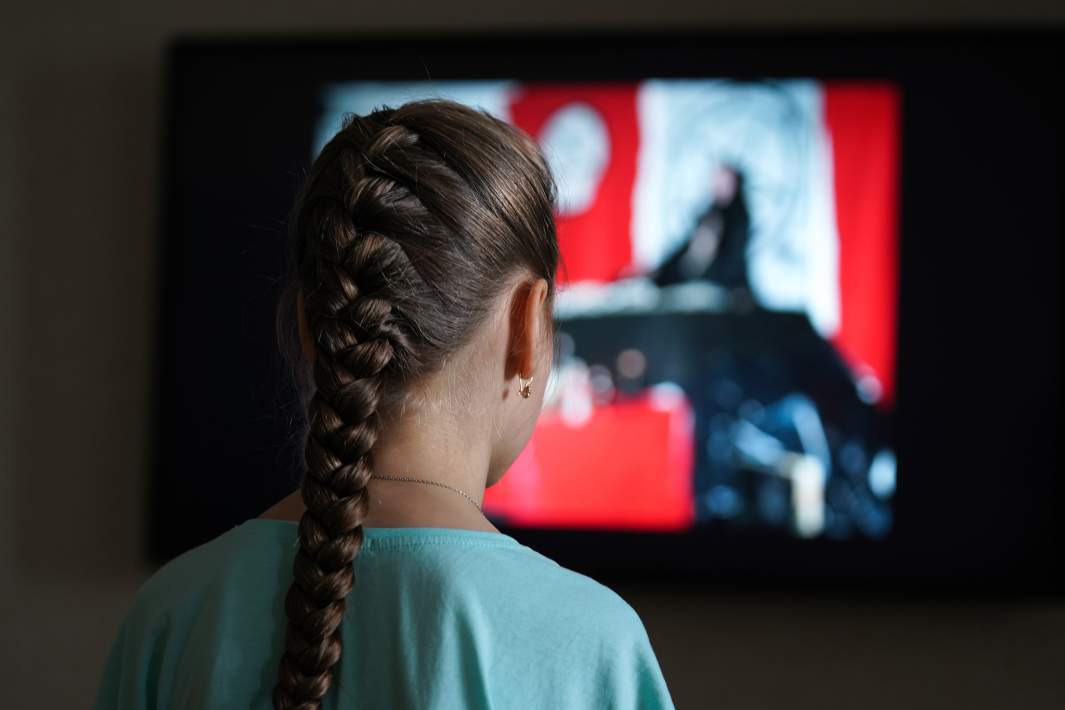 Девушка смотрит в телевизор 