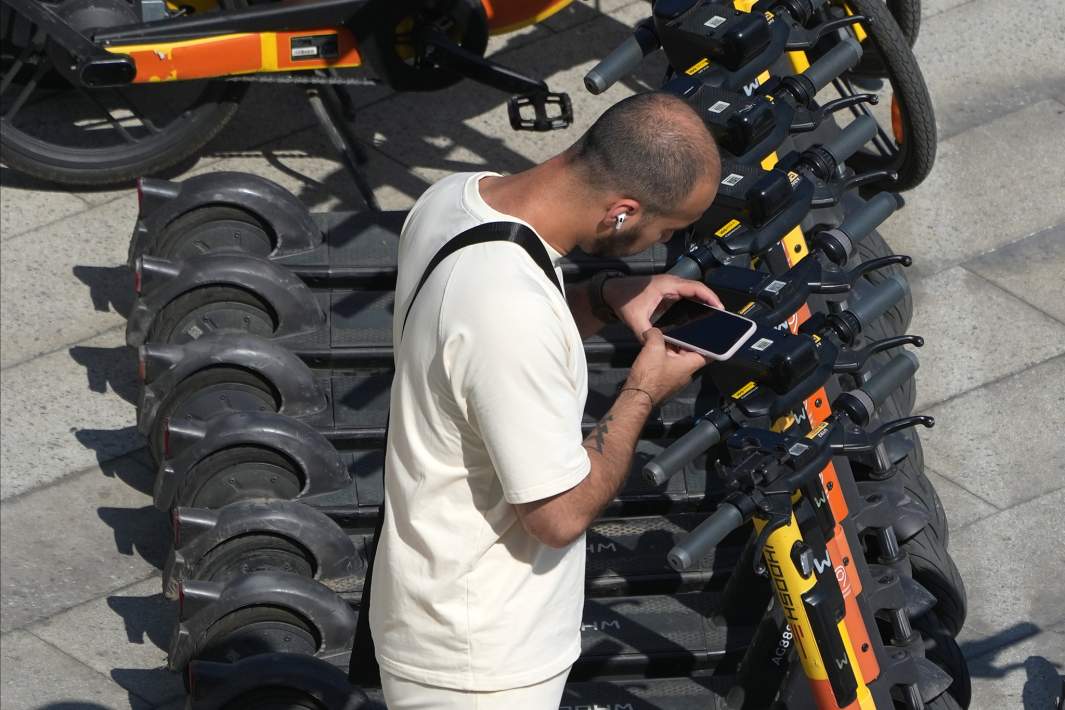 Мужчина у стоянки электросамокатов