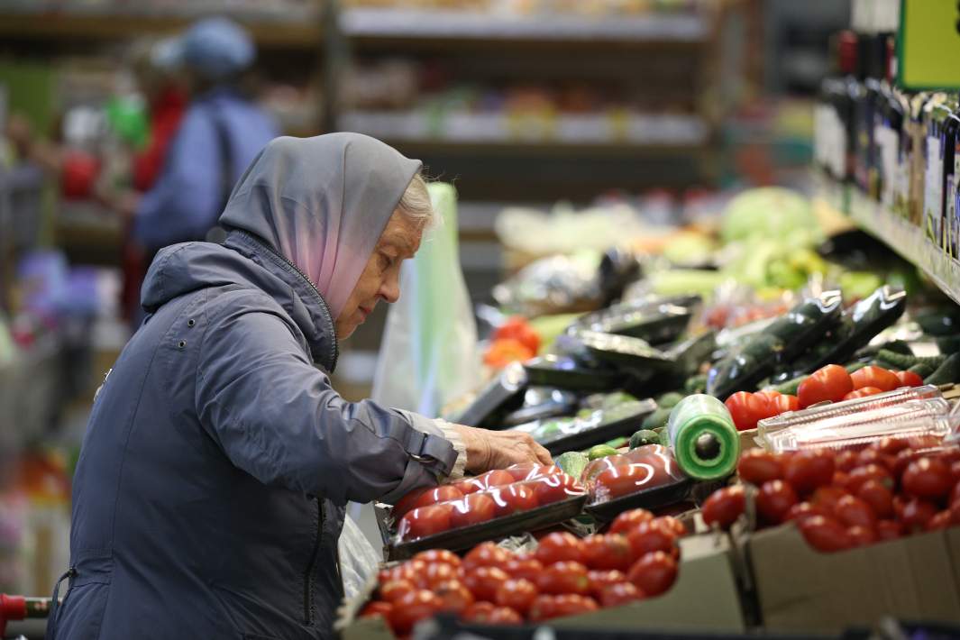 Пенсионерка покупает овощи 