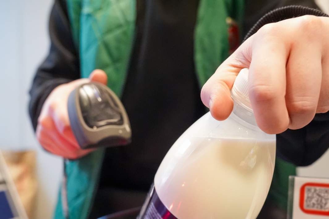 Продавец считывает цену товара сканером