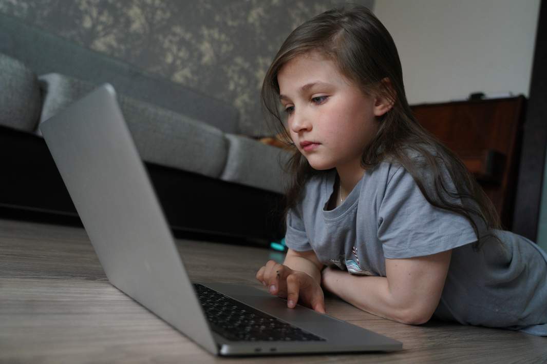 Девочка смотрит в ноутбук 