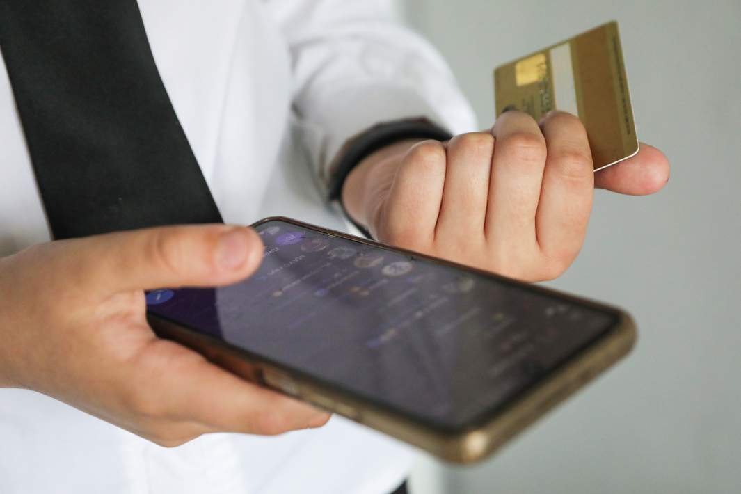 Банковская карта и смартфон в руках мужчины