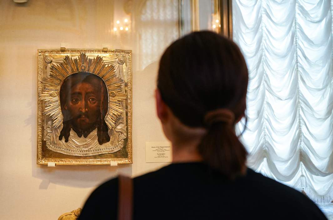Посетитель рассматривает икону «Спас нерукотворный» в галерее Государственного Эрмитажа