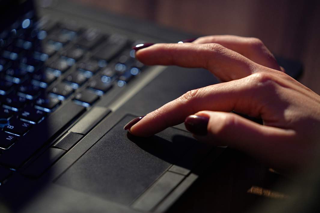 Женская рука на ноутбуке 