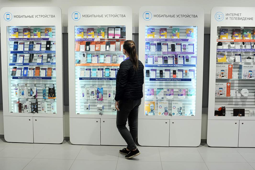 Покупатель возле стенда с мобильными устройствами