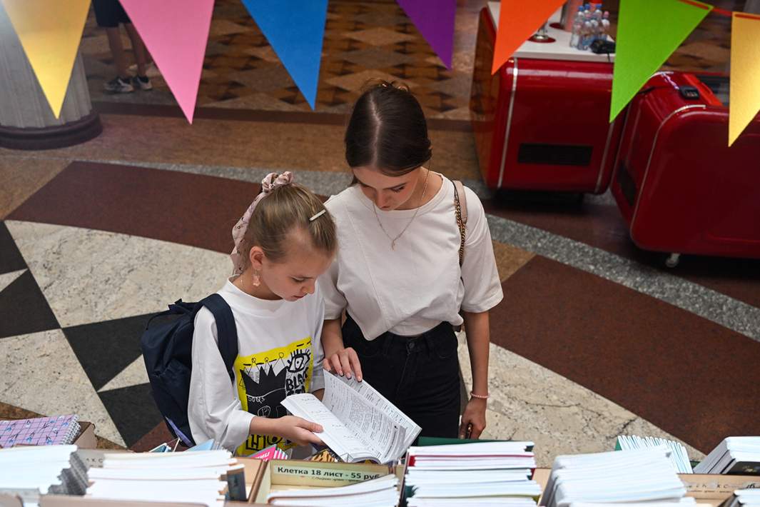 Посетители выбирают учебники на школьной ярмарке