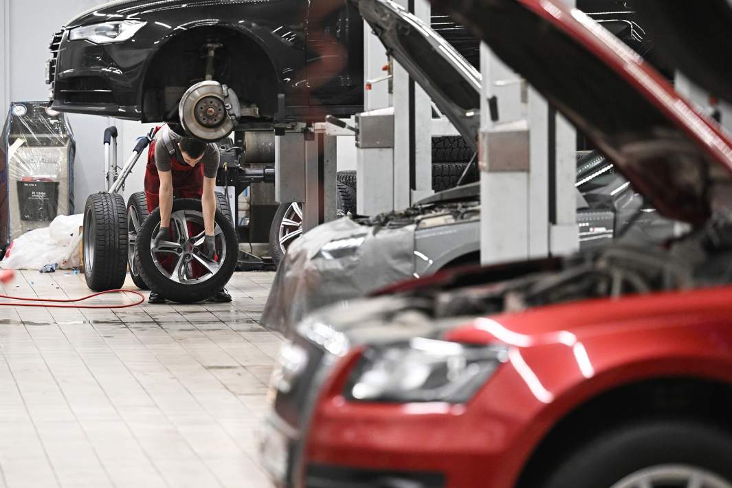 Автослесарь работает в сервисном центре автосалона