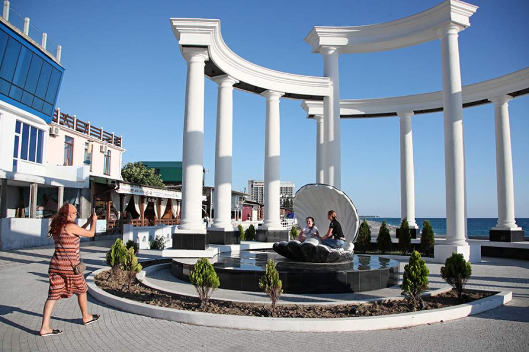 Туристы фотографируются на городской набережной Абхазии